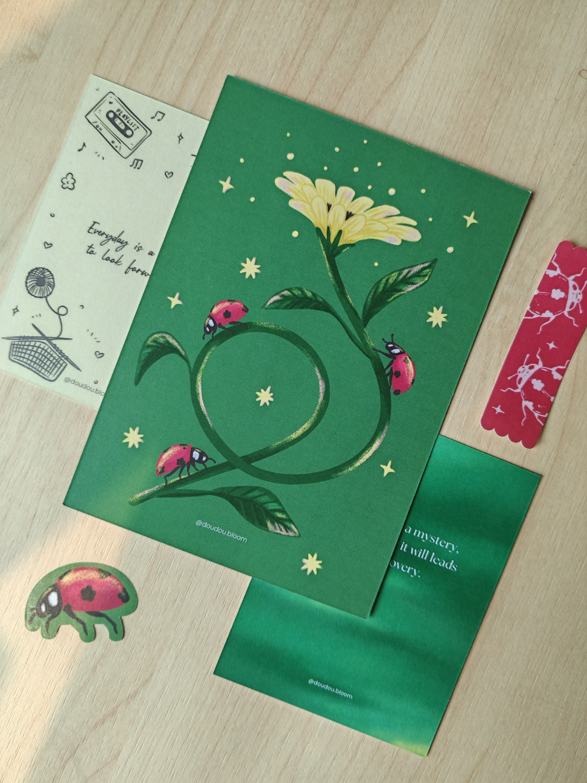 A snail mail postcard visual of red aby bugs crawling on a yellow bud flower, on a green background.